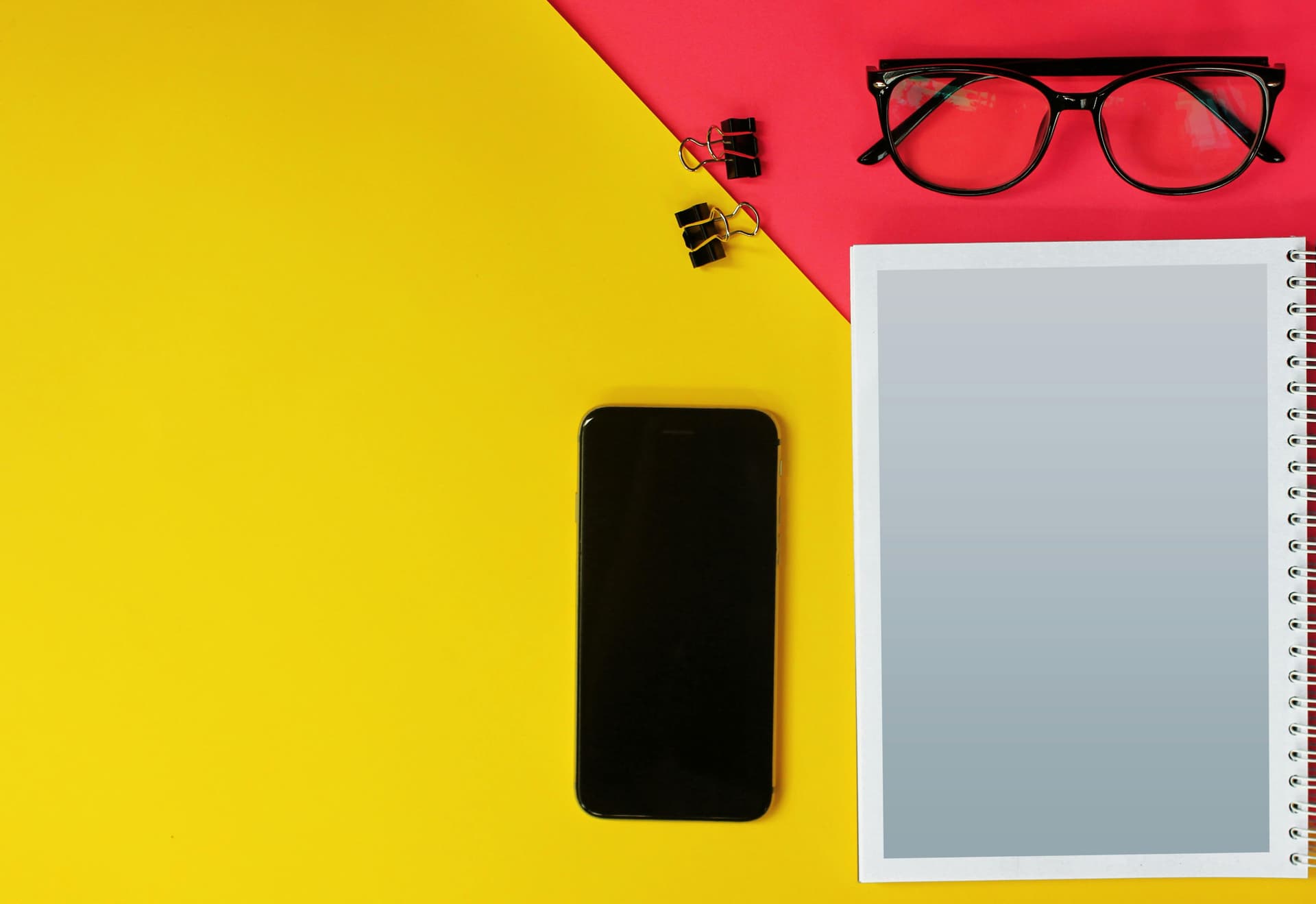 Black iPhone on a yellow table, symbolizing modern blog redesign with AI