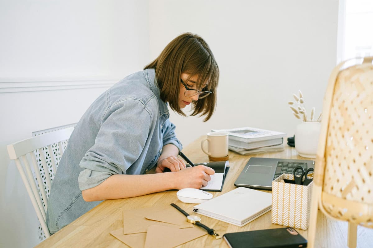 Woman writing in a notebook, representing blog planning and content creation