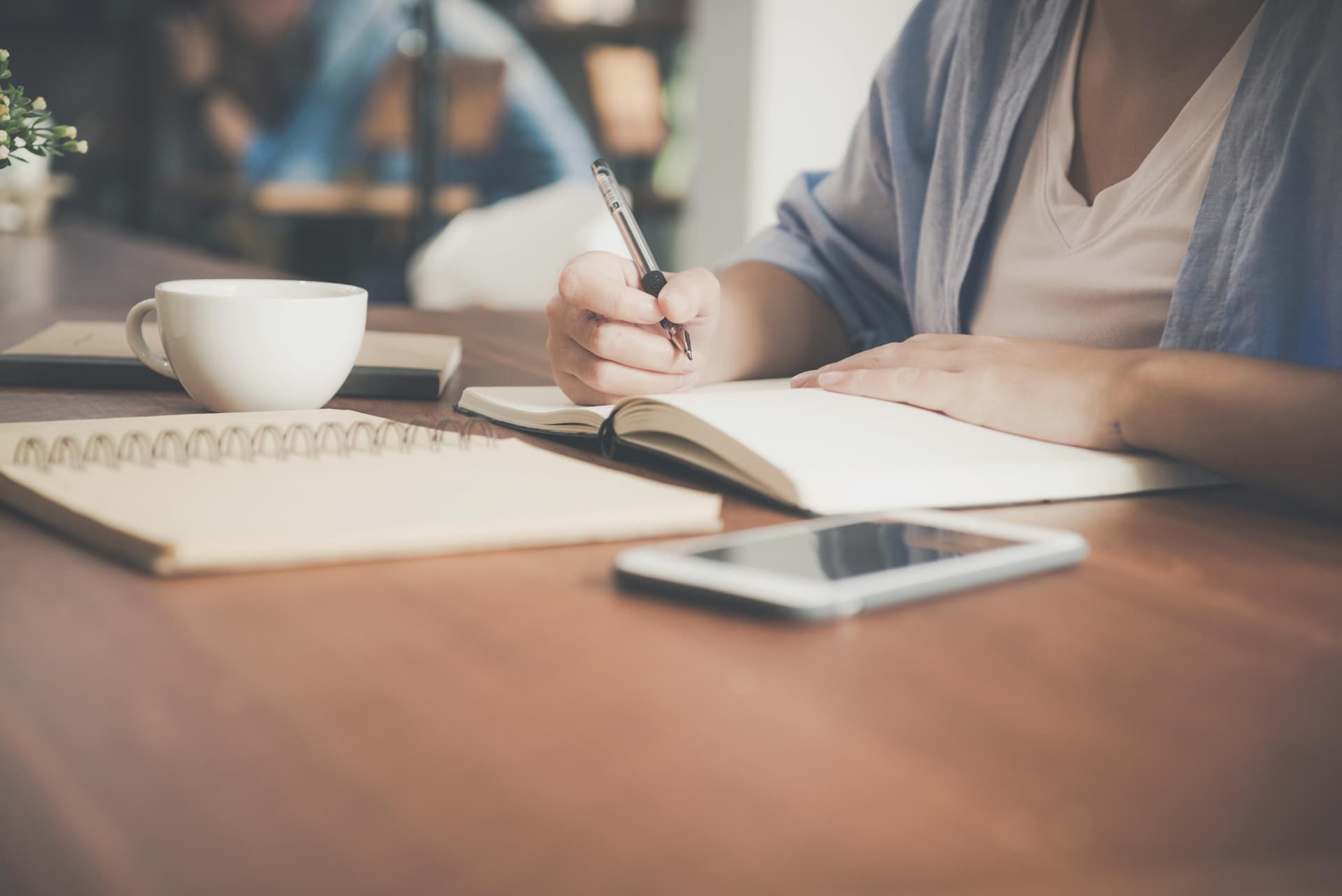 Woman writing in a notebook, representing blog planning and content creation